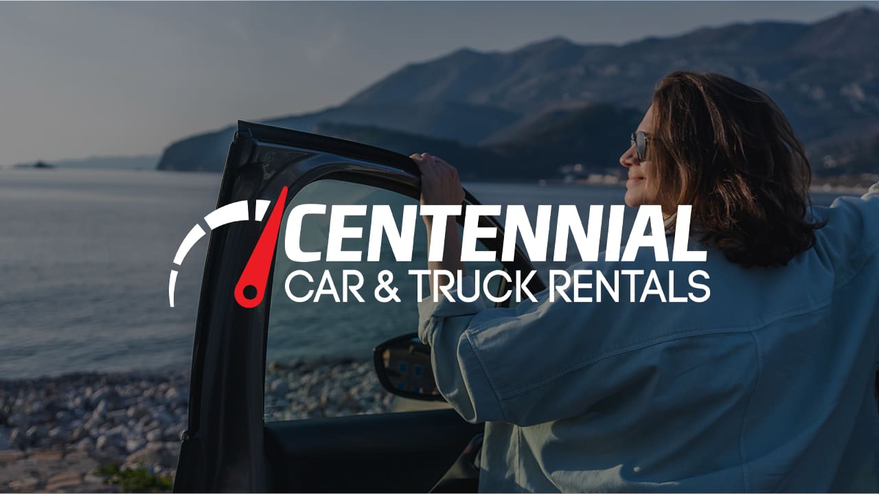 Road trip car holiday happy couple driving convertible car on summer travel Hawaii vacation. Woman with arms up having fun, young man driver